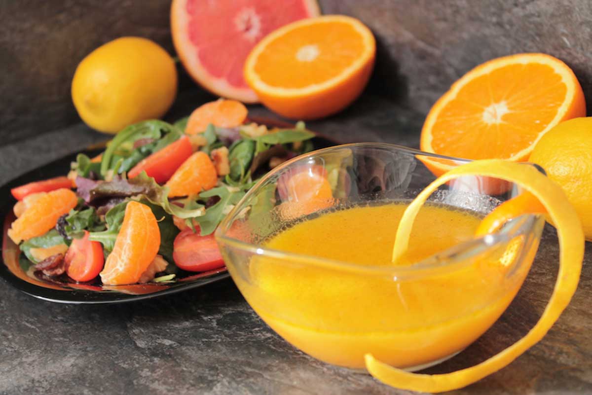 Vinagreta de zumo de naranja con una ensalada de fondo
